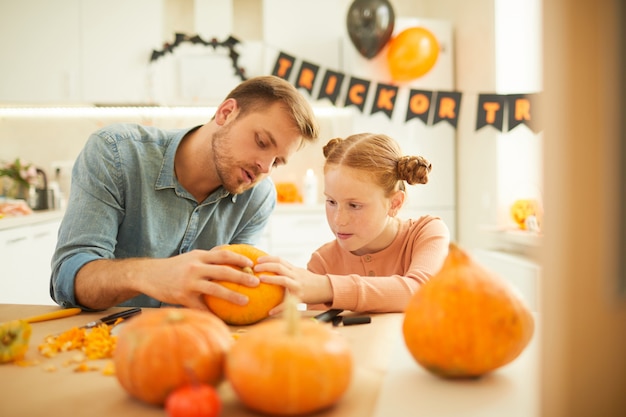 Family with pumpkins sitting at home