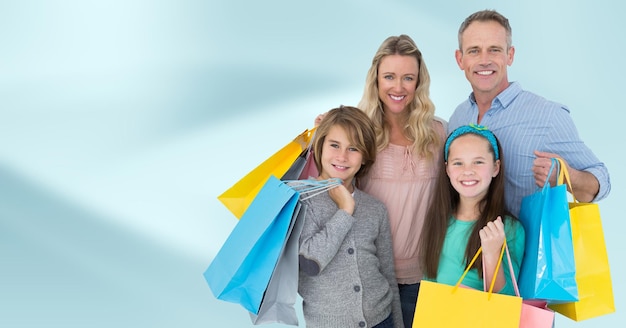 Family with shopping bags against blurry blue abstract background