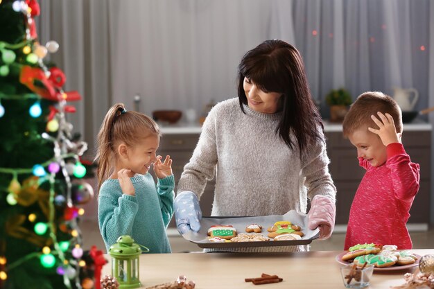 Family with tasty Christmas cookies in kitchen