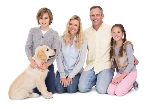 Family with their dog posing and smiling at camera together