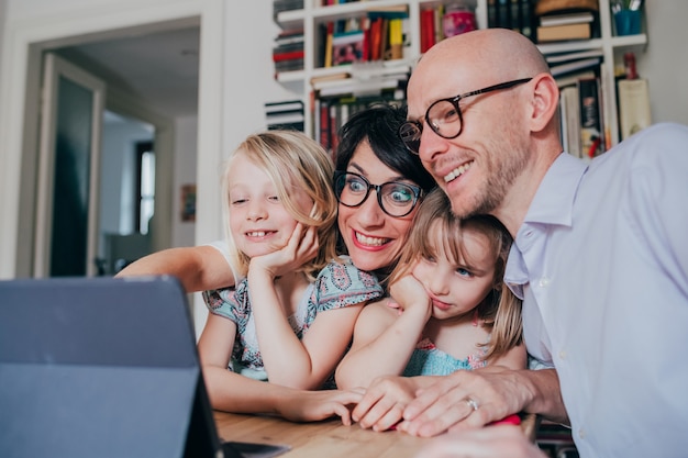 Famiglia con tre bambini al coperto con tavoletta