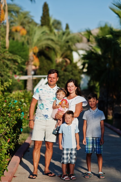 Family with three kids on Turkey resort against palms.