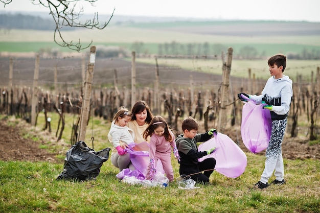 Family with trash bag collecting garbage while cleaning in the vineyards Environmental conservation and ecology recycling