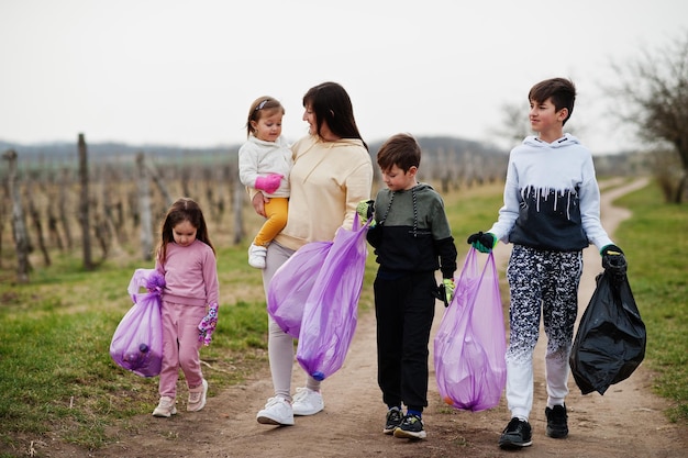 Family with trash bag collecting garbage while cleaning in the vineyards Environmental conservation and ecology recycling