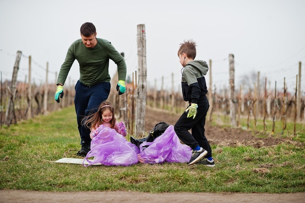 Family with trash bag collecting garbage while cleaning in the vineyards Environmental conservation and ecology recycling