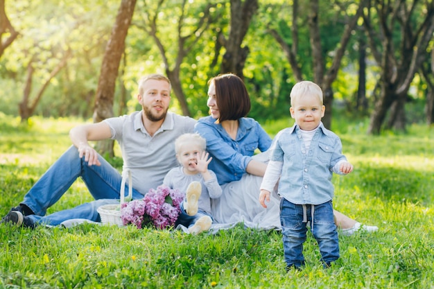 Family with two children rest in the summer garden