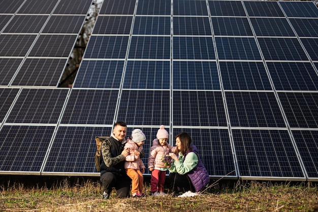 Family with two daughters on the background of solar panels Eco energy