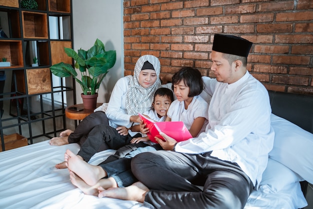 Семья с двумя детьми вместе читает книги