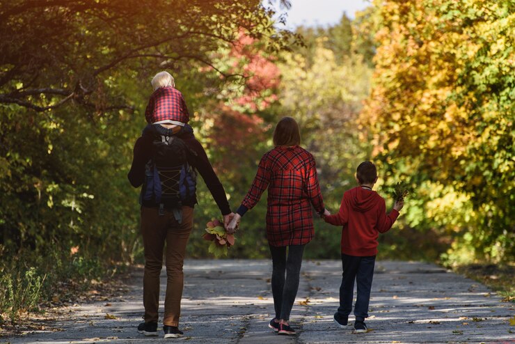 Family with two sons walking in the autumn forest.