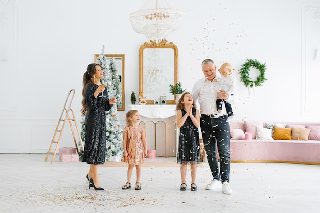 Family with young children playing with confetti at a New Year celebration a homely atmosphere Christmas