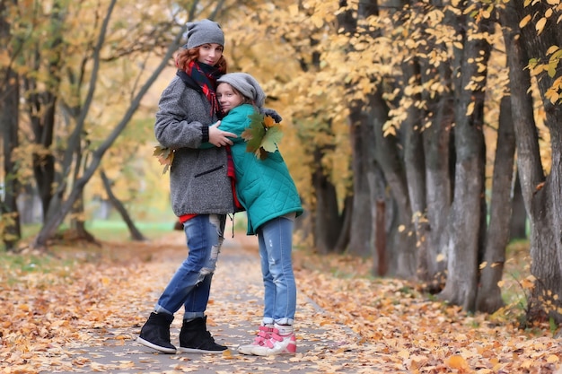 Family woman and daughter walk autumn park