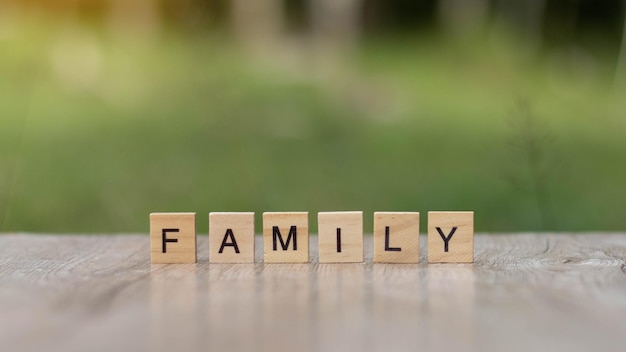 Foto parola di famiglia scritta con blocchi di legno sul tavolo sullo sfondo della natura