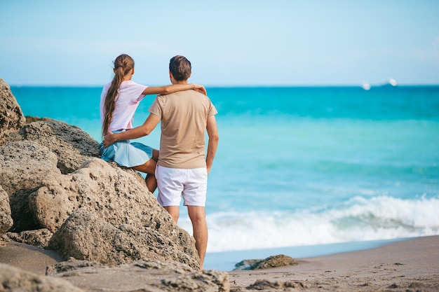 Family of young father and cute daughter enjoy the view of the sea on the beach