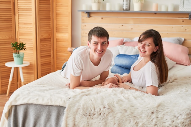 famiy young parents with a newborn baby at home on the bed