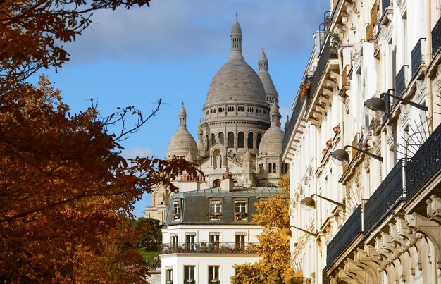 Foto la famosa basilica del sacre coeur e gli alberi autunnali in primo piano parigi francia