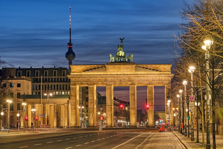 Photo the famous brandenburg gate in berlin with the television tower at dawn