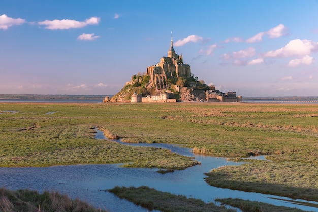 Famous castle Mont Saint Michel and the water meadows at sunset, Normandy, France