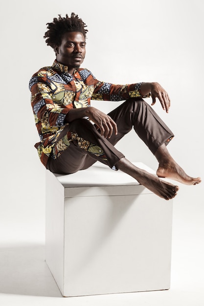 Famous and fashion african man posing on cube