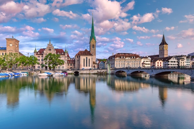 Famous fraumunster and st peter church with reflections in river limmat at sunrise in old town of zu...