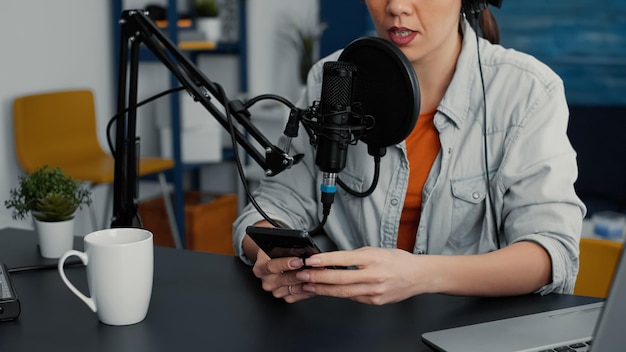 Famous online live radio talk show using smartphone to answer\
audience messages. popular social media influencer talking with\
public on live chat on mobile cell phone. studio shoot