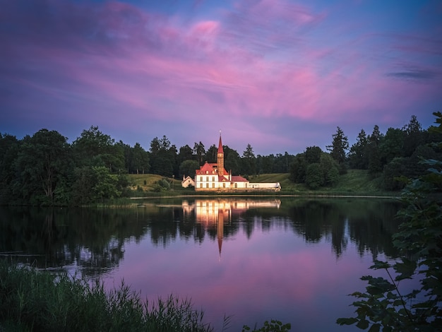 The famous Priory Palace during sunset, with colorful clouds under sunlight. Fairytale Castle in Gatchina, Russia.