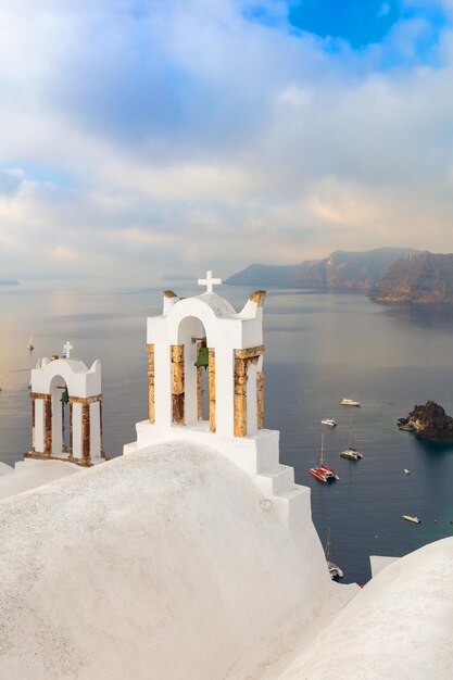 写真 サントリーニ島 - ギリシャの島サントリーニの有名な建築のコンセプト構成白い鐘のアーチと青い海の景色サントリニ島ギリシャヨーロッパ