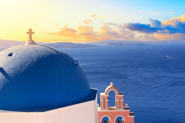 Foto famosa vista iconica di santorini chiesa di sant'anastasi durante il tramonto villaggio di oia isola di santorini in grecia