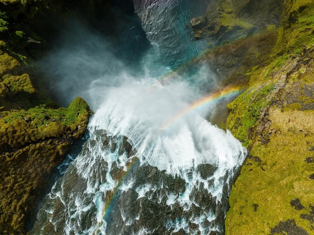 Famous skogafoss waterfall with a rainbow dramatic scenery of iceland during sunset