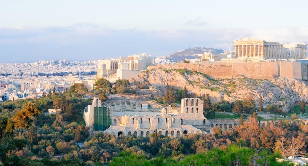 Photo famous skyline of athens with acropolis hill at sunset pathenon herodes atticus amphitheater and lycabettus hill athens greece