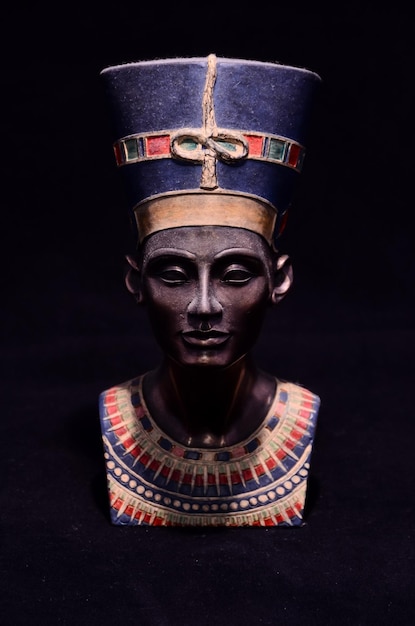 famous statuette bust of queen nefertiti isolated on black background