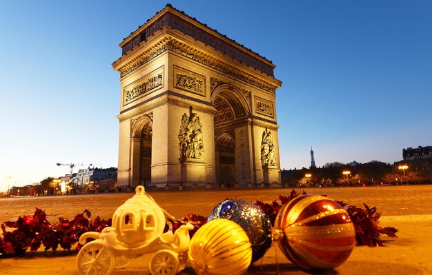 The famous Triumphal Arch at night and Christmas baubles Paris France