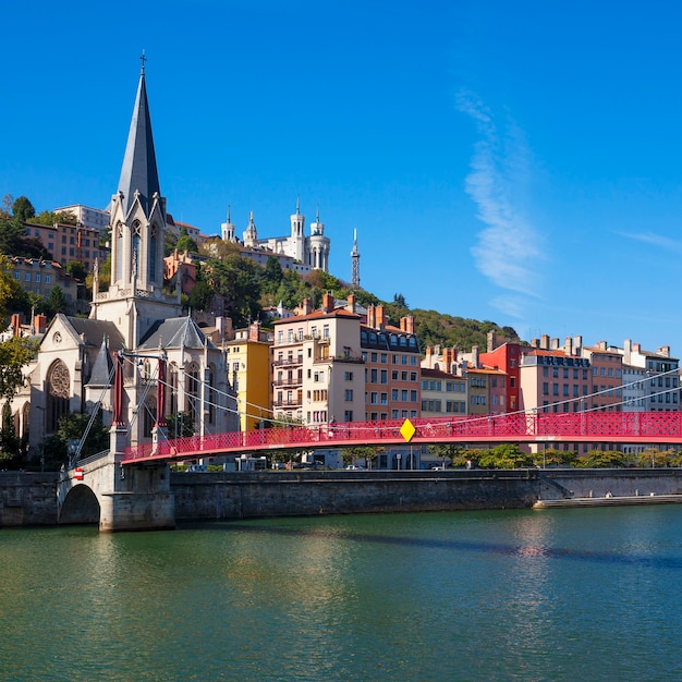 Famous view of Lyon city with red footbridge on Saone river and church