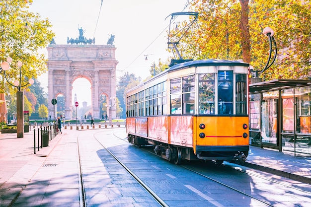 Famous vintage tram in the centre of the Old Town of Milan in the sunny day Lombardia Italy Arch of Peace or Arco della Pace on the background