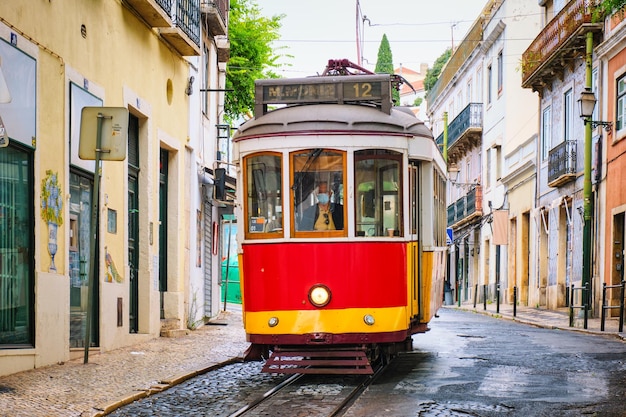 Famous vintage yellow tram in the narrow streets of alfama district in lisbon portugal