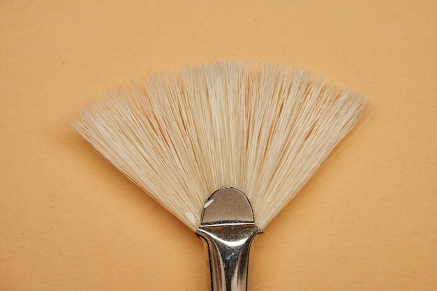 Photo fan brush with natural hog bristles on a yellow background
