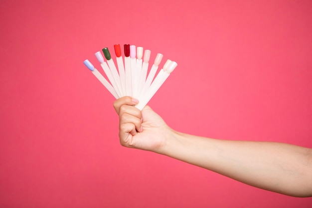 Fan of nail art polish tips samples in woman hand