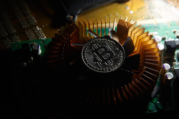 A fan with a bitcoin on it sits on a computer chip cryptocurrency bitcoin on a chip blockchain