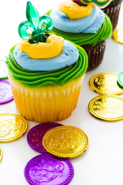 Foto cupcakes fantasia decorati con foglia e maschera per la festa del mardi gras.