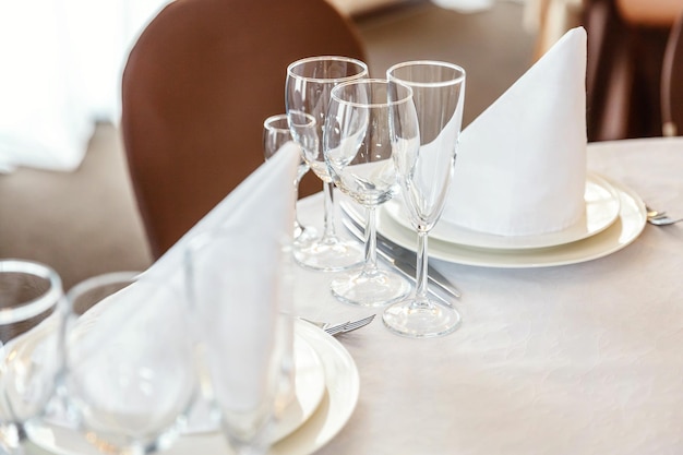 레스토랑 고급스러운 인테리어 배경 웨딩 엘레그에서 냅킨 잔을 곁들인 저녁 식사를 위한 멋진 테이블
