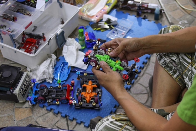 Поклонники мини-гоночного автомобиля Tamiya готовят игрушечный автомобиль Tamiya
