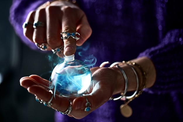 Fantasie heks tovenaarsvrouw die betoverende magische elixirdrankfles gebruikt voor liefdesspreuk, hekserij en waarzeggerij. Magische illustratie en alchemie