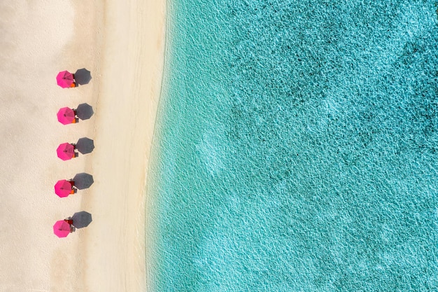 素晴らしい空撮、ターコイズ ブルーの海に近いパラソルとラウンジ チェア ベッドのある素晴らしいビーチ