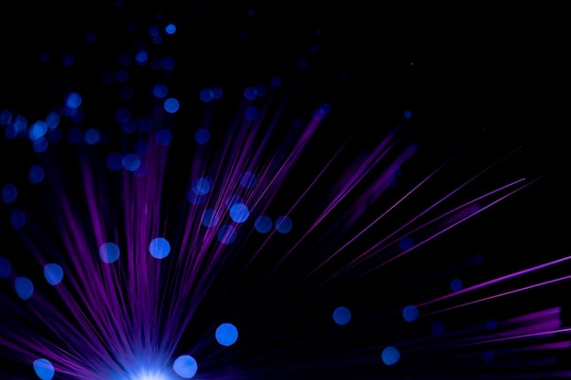 Fantastic backdrop of illuminated neon purple fiber optic lines and glowing blue bokeh on black