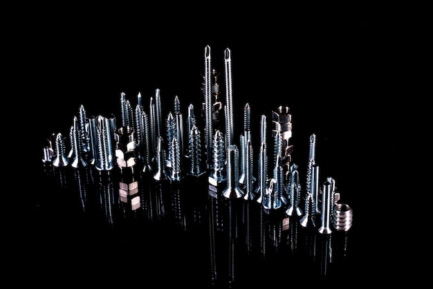 A fantastic city made of bolts nuts screws and selfcuts on a black background with reflection