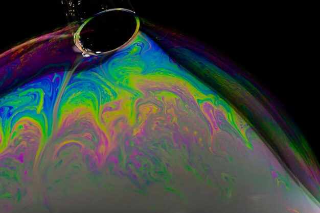 Photo fantastic close-up shot of soap bubble with plastic tube through which air is blown in