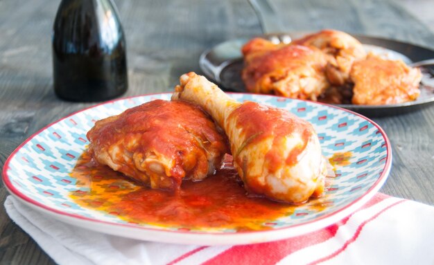 Foto fantastico pollo fritto in padella con pomodoro.