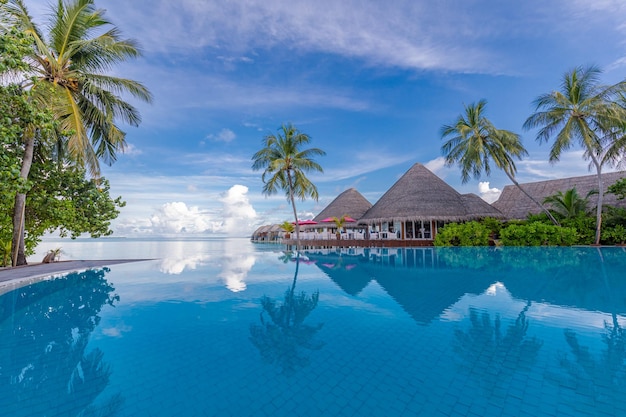 Fantastico bordo piscina, cielo al tramonto, riflesso di palme. spiaggia tropicale di lusso, bellissimo paesaggio
