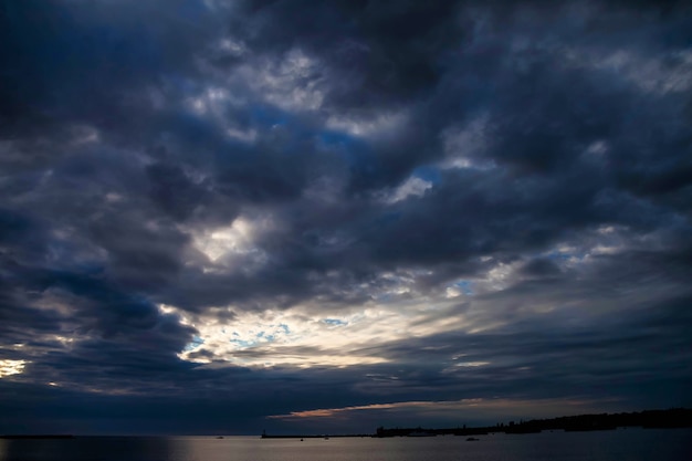 Fantastica vista del cielo nuvoloso scuro in mare. drammatica e pittoresca scena del tempo serale. sfondi pubblicitari per sito o sfondi ad alta risoluzione. concetto di natura, turismo e avventura