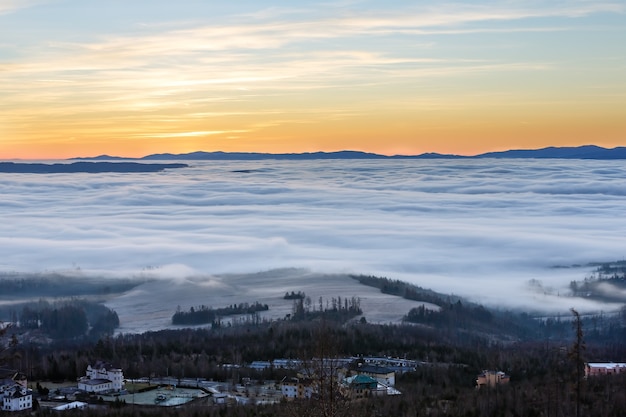 Fantastical sunrise view with colorful sky and clouds over foothills.