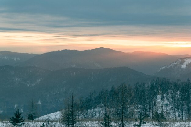 Fantastisch panoramisch uitzicht op het bergdal bij zonsondergang. Een zonnestraal raakt de grond.